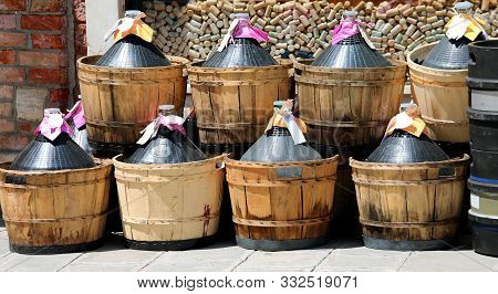 Many Capacious Demijohns Of Wine Outside A Wine Bar