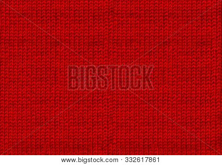 Ugly sweater Christmas party. Red knitted woolen Christmas background. The atmosphere of a warm sweater. New year backdrop. Texture of the wool or acrylic knit. Base for winter design