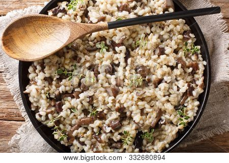 Traditional Orzotto (perlotto) With Forest Porcini Mushrooms And Thyme Closeup On A Plate. Horizonta