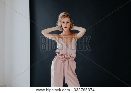 Portrait Of A Beautiful Fashionable Blonde Woman In A Pink In A Black White Room
