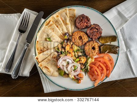 From Above View Of Greek Vegetarian Sample With Falafel, Pita And Dolmades Takeout Food Plated At Ho