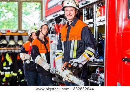 Professional fire fighters attaching hose at hose laying vehiclero