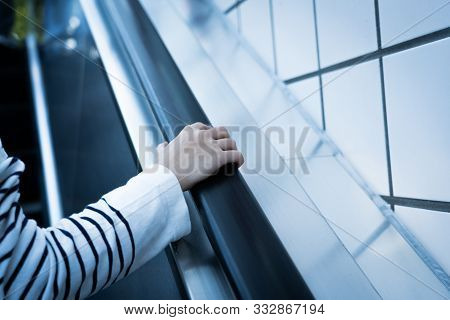 Close Up Image Of Hand Holding An Escalator Handrail