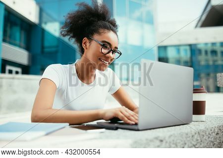 African American College Girl Using Laptop Learning Online Outdoors