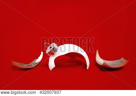 White Broken Glass Bauble On Red Christmas Background. Winter Holiday Season Depression And Stress, 