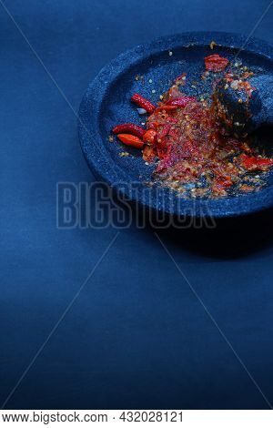 Red Chili Sauce On A Stone Mortar And Pestle. Dark Background, Focus Selected.