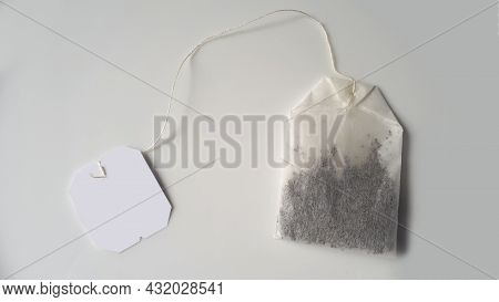 Black Tea Bag With A White Label On A Grey-white Background. White Tea Bag