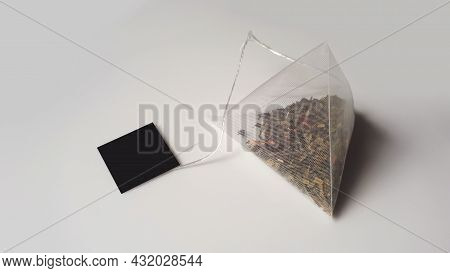 Pyramid Tea Bag On A Grey-white Background With A Black Label . Pyramid Shape Tea Bag. Transparent T