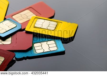 Different Sim Cards On Grey Background, Closeup