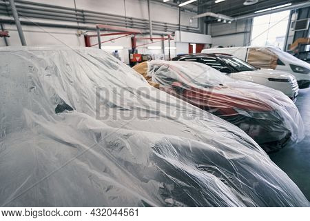 Cars Standing In Line With Dustsheets On Them