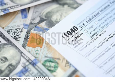 1040 Us Tax Form With Dollars On Table Closeup