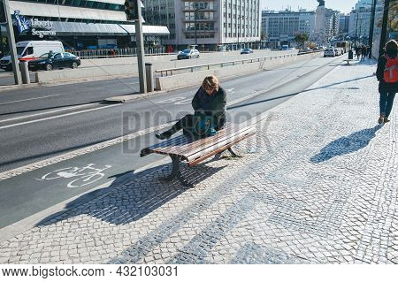 Lisbon, Portugal - Feb 8, 2018: Woman Resting On Publick Bench In Central Lisbon On A Warm Winter Da