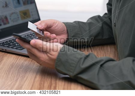 Man Holding Credit Card And Smartphone In Hand For Make Online Banking, Making A Payment Or Purchasi