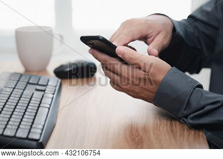 Business Man Holding Smartphone And Touch On Screen For Online Working And Use Desktop Computer Work