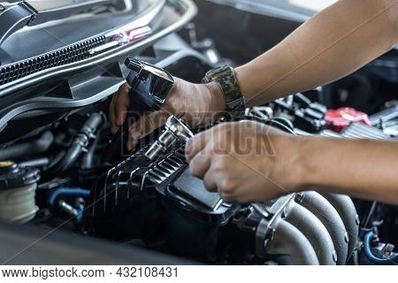 Close Up Spark Plug Coil On Engine Cover And A Man Use Block Wrench Remove A Bolt For Take Off Coil 