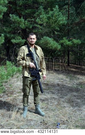 Man with KRISS Vector 9*21 caliber submachine gun in the forest. Unformal shooting range near Kiev. September 6,2021. Kiev Region, Ukraine