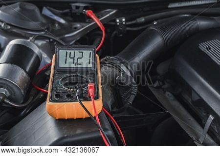 Voltage Of The Car's Starter Battery Is Measured By A Multimeter. Voltage Is About 14 Volts When The