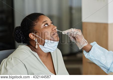 Woman Letting Doctor In Protective Glove To Get Nasal Swab For Sending It To Lab For Testing