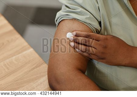 Close-up Image Of Female Patient Putting Cotton Ball On Site Of Injection After Getting Vaccinated