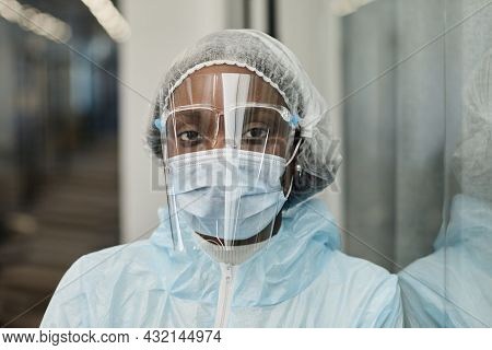 Face Of Tired Black Medical Nurse In Ppe Suit, Medical Mask And Face Shield Protecting From Coronavi