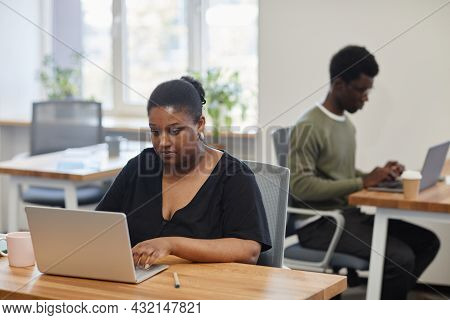 Concentarted Female Entrepreneur Working On Laptop, She Is Reading Article Or Report Online