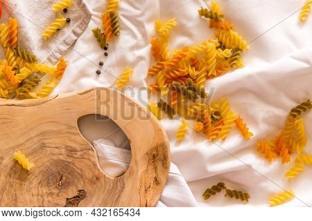 Fragment Of Cutting Board Curved Shape Of Olive Tree, Scattered Around Pasta, Garlic, Pepper. They L
