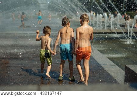 Three Caucasian Boys Going To Run Throgh Splashing Fountain On Hot Summer Day In City Of Saint-peter