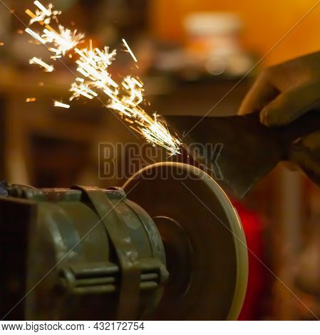 Sharpen The Knife On The Abrasive Wheel, Sparks Fly From Grinding Metal.