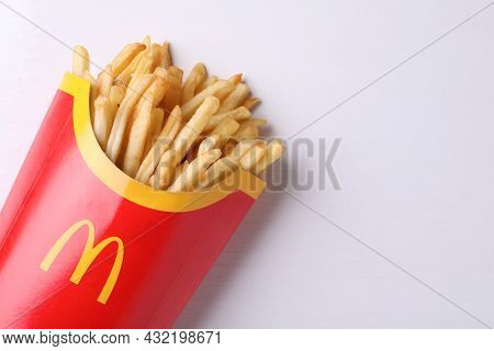 Mykolaiv, Ukraine - August 12, 2021: Big Portion Of Mcdonald's French Fries On White Wooden Table, T