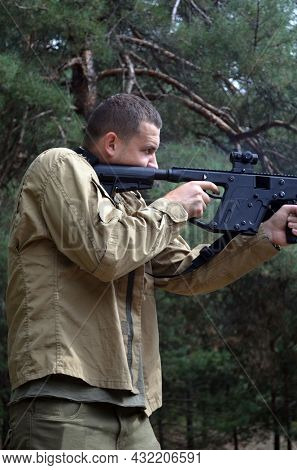 Man with KRISS Vector 9*21 caliber submachine gun in the forest. Unformal shooting range near Kiev. September 6,2021. Kiev Region, Ukraine