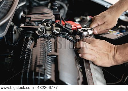 Closeup Spanner In Hand Male Mechanic Repairs Car In Garage. Car Maintenance And Auto Service Garage
