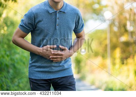 Abdominal Pain When Walking Outdoors, Man With Stomach Ache On Nature Background