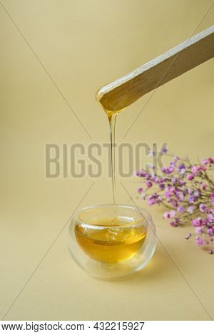 Depilation And Beauty Concept - Sugar Paste Or Wax, Honey For Hair Removal Drips From Wooden Wax Sti