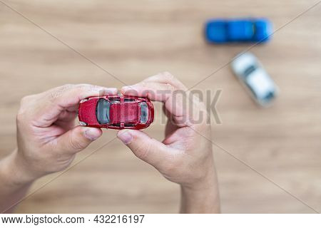 Damaged Toy Car In The Man\'s Hand And New Car On The Floor : Accident Comparison Of Car Toy