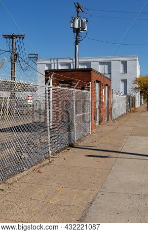 Sidewalk Alongside A Commercial Industrial Facility, Newer Chain Link Fence And Barbed Wire, Power P