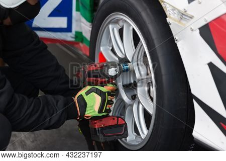 A Team Changing Tires On A Racing Car On Pit Lane. Tire Change During At Pit Stop