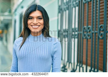 Beautiful hispanic woman smiling confient at the city