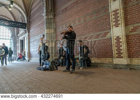 Amsterdam Holland - August 17 2017: Musical Quartet Busking In City Street In Covered Arched Walkway