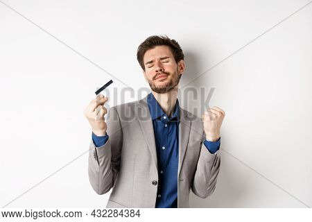 Excited Successful Businessman Dancing With Plastic Credit Card, Raising Fist Pumps And Smiling Deli