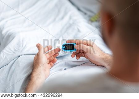 Patient Lying At Bed And Wear A Pulse Oximeter. View From The Shoulders. Concept Of Determination Of