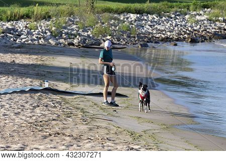 Manitowoc Wi Usa September  07 2021: Young Girl With A Dog On The Beach Lake Michigan.