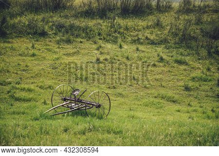 Scenic Green Landscape With Old Altaic Horse Plow With Saddle In Field Among Lush Grasses. Minimalis