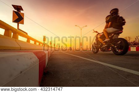 Solar Panel Energy On Yellow Curve Traffic Sign And Motion Blur Of Biker Riding Motorcycle On Curve 