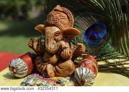 Beautiful Lord Ganesha Idol Worshiped During Ganesh Chaturthi Festival With Peacock Feather In Backg