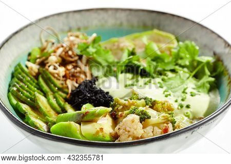 Vegan food - poke bowl with vegetables, edamame beans, soybean sprouts. Poke bowl with avocado and vegetables isolated on white background. Eat less meat. Plant - based eating