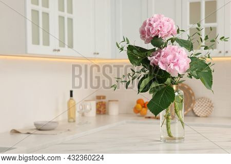 Beautiful Pink Hortensia Flowers In Vase On Kitchen Table. Space For Text
