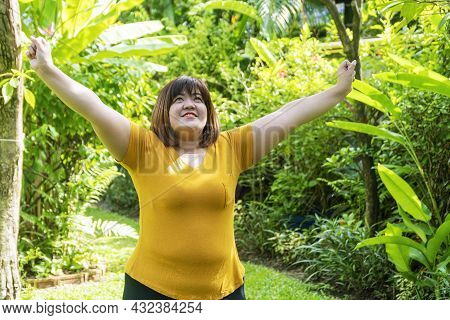 Healthy Weight Loss Concept. Happy Overweight Young Woman Stretching Before Workout In The Garden. F
