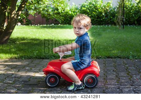 Todder menino brincando com carro de brinquedo grande