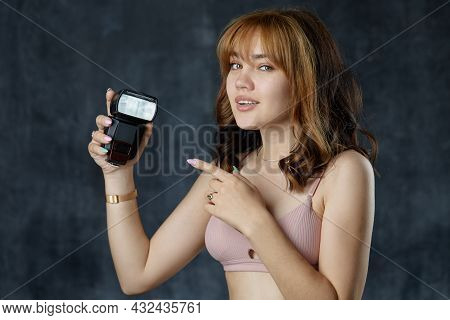 A Beautiful Girl Holds A Flashbulb In Her Hands. Photo Accessories. Teaching Photography How To Use 