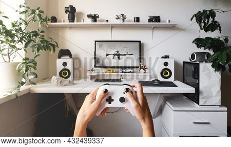 Close-up Of Male Hands Holding White Wireless Gamepad Against White Computer Dream Desk.